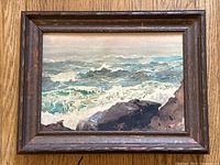 Front view of framed seascape watercolor painting showing waves crashing on rocks