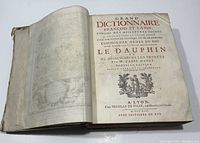 Open book displaying title page with red and black text showing title, author, publisher, and publication year 1713 in French.