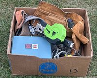 Box of assorted hand tools including tool belt, stud finder, and blue metal tool case.