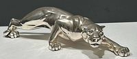 Front angle view of the silver-tone panther/jaguar sculpture showing stalking pose and detailed facial features.