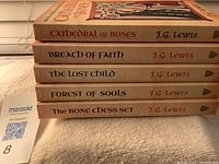 Spine view of five J.G. Lewis books with titles and author name visible