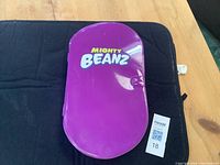 Closed purple Mighty Beanz storage container, oval shaped plastic case with Mighty Beanz logo on front.