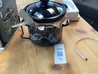 Star Wars slow cooker with lid and power cord on wooden table alongside MaxSold lot tag