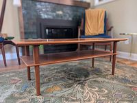 Full view of teak coffee table showing top surface, shelf and legs