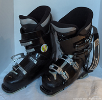 Front and side view of black Fischer women's ski boots with foam lining and four buckles.