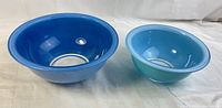 Two blue Pyrex nesting bowls side by side, showing size difference and exterior surface.