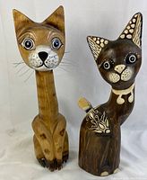 Front view of both wooden cat figurines showing details and paint