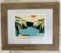 Framed Algonquin Provincial Park print centered with light brown wooden frame and white matting.
