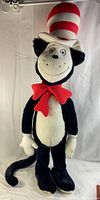 Full body image of the extra tall Cat in the Hat plush toy showing black and white plush with red and white striped hat and red bow tie.