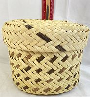 Front view showing basket with lid and measurement scale behind to indicate size and height.