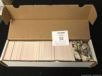 Box filled with two full sets of 1991 Score hockey cards, 328 cards each, packed with some paper.