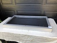 Top view of closed aluminum display case with plexiglass top on table with white cloth