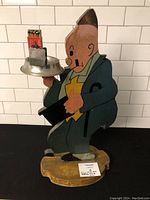 Full view of wooden Jiggs ashtray stand with metal ashtray and match holder with vintage matches in it.