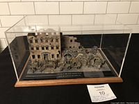 Overall view of full diorama scene inside a transparent display case with wooden base