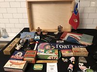 Overview of the lot showing wooden box, Pennant, flags, tins, scissors, small figurines.