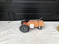 Metal firetruck lawn sprinkler side view showing large rear wheels and curved sprinkler arm