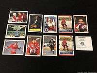 Full view of all 10 Eric Lindros hockey cards displayed on black surface, showing front designs