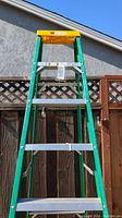Full front view of the Davidson 7 foot ladder with yellow tool tray at top and fiberglass rails.