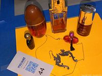 Full lot overview showing 4 perfume bottles and a pair of sterling silver dragon motif earrings on orange background.