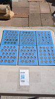 Six blue cardboard coin holders arranged in two rows with multiple U.S. coins in slots labeled with years and mints.