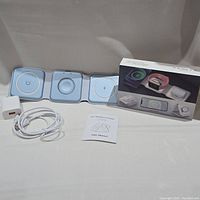 Photo of the 3 in 1 wireless charging set including charging pad, power adapter, USB cable, user manual, and product box.