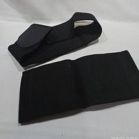 Photo showing the black elastic ankle brace with adjustable strap and Velcro.