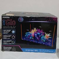 Front of Marina iGlo Aquarium Kit box showing aquarium with multi-color LED lighting and fish, plus feature highlights.
