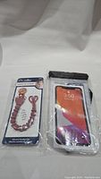 Photo of new pink silicone pacifier clip with beads and a new waterproof phone protector case with a phone display shown in the pouch.