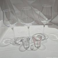Photo showing the set of three clear, angled bowl wine glasses and two shot glasses with measurement markings.