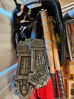 Photo of foam tombstone decorations and wooden bats wrapped with lights inside a laundry basket.