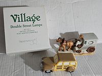 Box and street lamps displayed alongside horse and vintage car