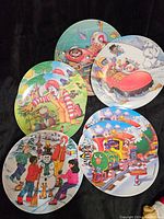 Five vintage McDonald's collectible plates showing Ronald McDonald in festive and winter scenes with children and animals.