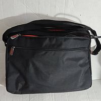 Front view of black laptop bag with zippers closed