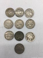 Top view of 10 US collectible five cent coins arranged in two rows showing obverse sides of Buffalo Indian Head and Jefferson Nickels.