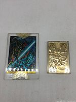 Two collectible cards displayed flat, one Pokemon gold-plated Mewtwo card, and one Union Wizard Series holographic card.