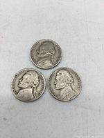 Front sides of three Jefferson nickels showing Thomas Jefferson profile, various years.