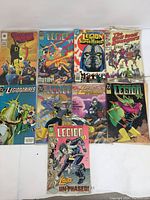 Photo of 9 vintage comics arranged in two rows showing various Legion of Super-Heroes, Legionnaires, and The Red Core Roughriders titles.