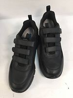 Pair of black men's walking shoes with three velcro straps, shown from the top