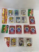 Top view showing multiple sealed and loose 1988 Score baseball player card packs and several single cards in clear protective sleeves.