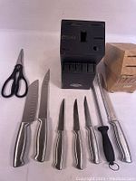 Photo of assorted cutting tools and two knife stands laid out showing all included knives and scissors.