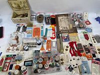 Overhead view of assorted sewing and craft items including threads, buttons, tools, and a sewing basket