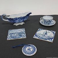 Antique flow blue gravy boat with blue ceramic coasters and blue danube demitasse cup and saucer