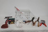 Full lot of outdoor aids including milk crate, flag, foot pump, rope, fishing line, hedge trimmers, and multi-tool shown from front angle.