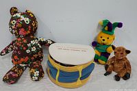 Full lot of four plush toys including Holly Doll by Sybil floral bear, Ty Gizmo Beanie Baby lemur, Vintage Disney Silly Symphony Band fabric drum, and MGI Mardi Gras Jester teddy bear