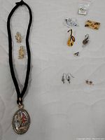 Overview of all jewelry items including necklace, pins, earrings with musical and Victorian themes