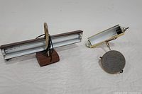 Wide shot showing two vintage desk lamps: a rectangular Tensor gooseneck lamp on a wood-tone base and a brass lamp with cylindrical shade and adjustable arm