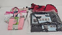Photo showing set of six bags including polka dot and pink shower totes, black suitcases wrapped in plastic, and red duffle bag