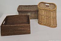 Three used display baskets arranged together on a white surface showing different shapes and weave styles.
