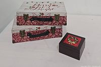 Full view of two Merry & Bright decorative storage boxes stacked with a small wooden box with holiday design on top right side.