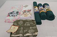 Overview of all items including 2 bunny tea towels, 5 green tea towels, and 3 shelf liners in rolls.